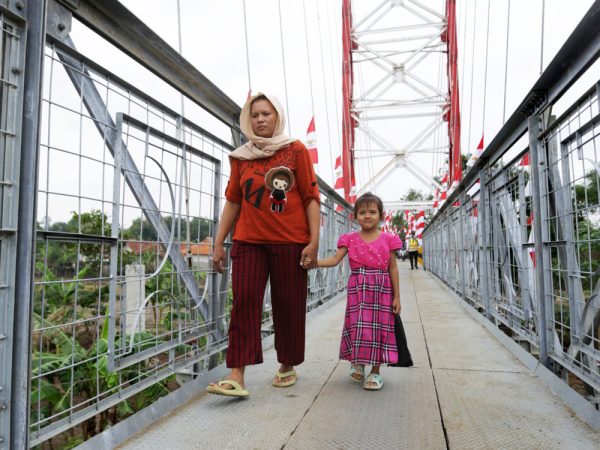 Seorang ibu bersama anaknya dari perbatasn  Kabupaten Subang melewati Jembatan Gantung Baleraja Kecamatan Gantar Kabupaten Indramayu, Jawa Barat, Senin 27 November 2023.(FOTO UTOYO PRIE ACHDI) 